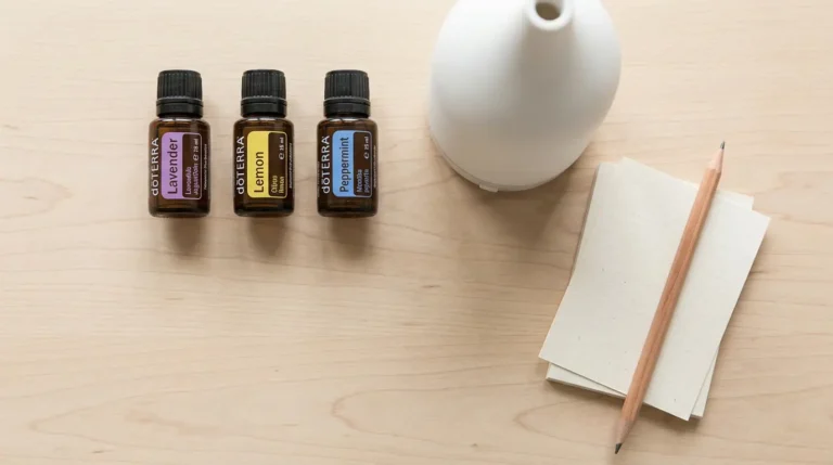 Trzy olejki doTERRA i prosty dyfuzor ułożone na jasnym stole jako pomoc w pierwszym wyborze.